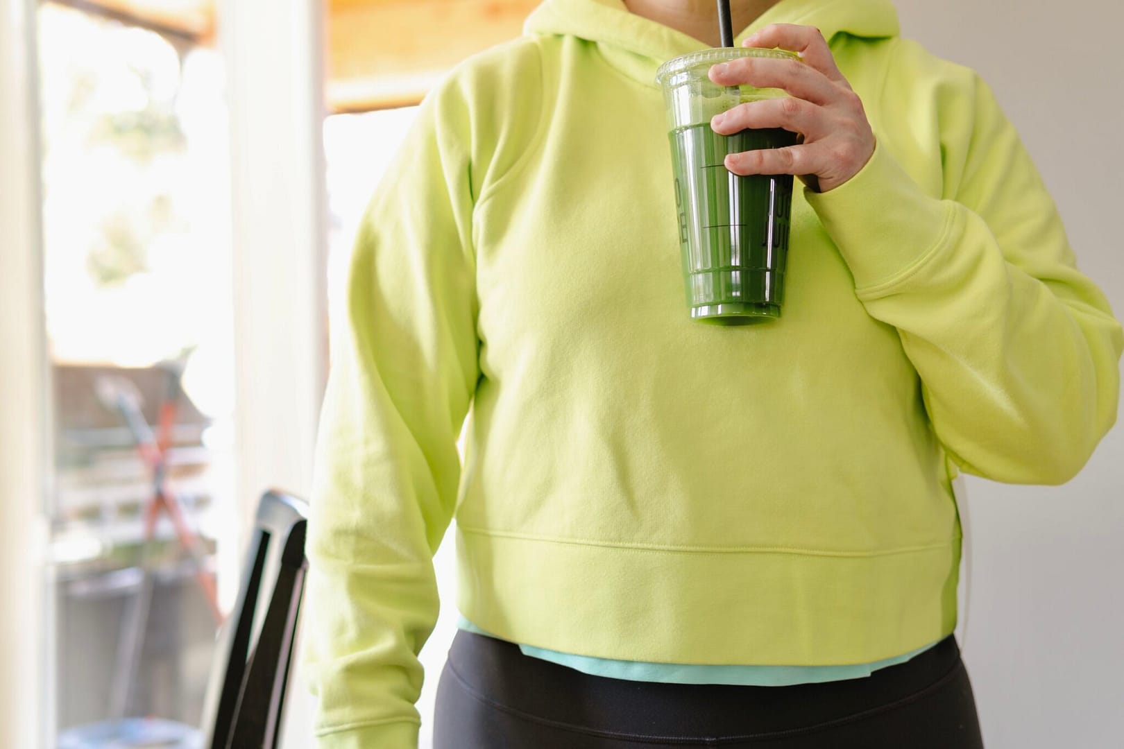 wearing a bright neon lululemon hoodie - lululemon sweatshirt - cropped lululemon sweatshirt in electric lemon - loungefull cropped hoodie