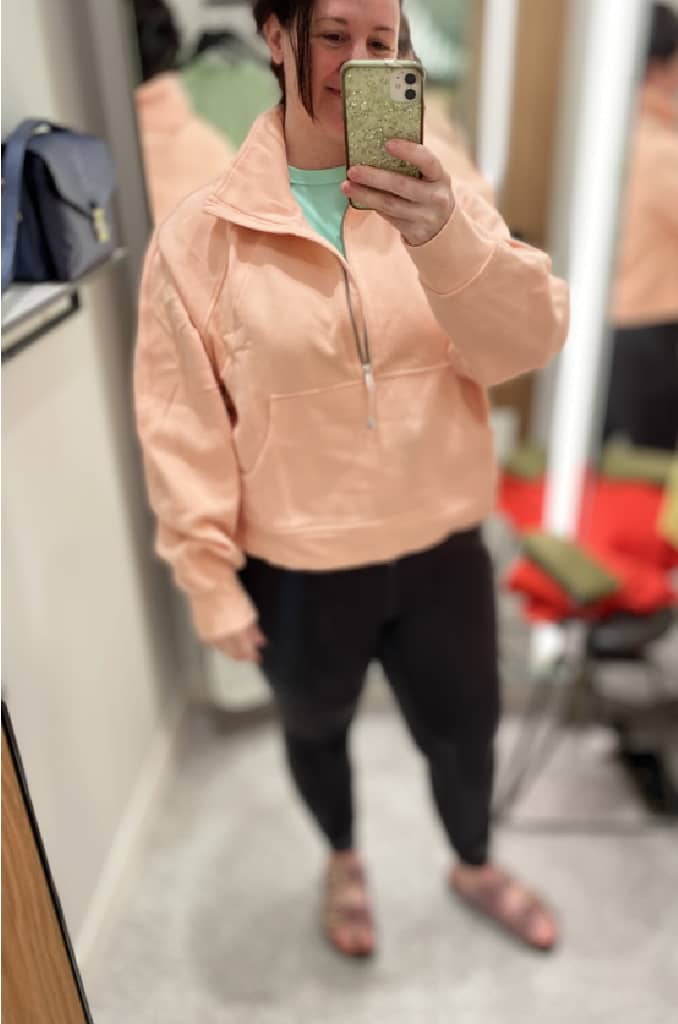 woman trying on pink sweater