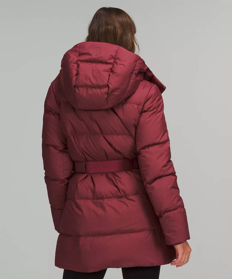 woman showing back details and wearing maroon Wunder Puff Waist Jacket from lululemon Restocks